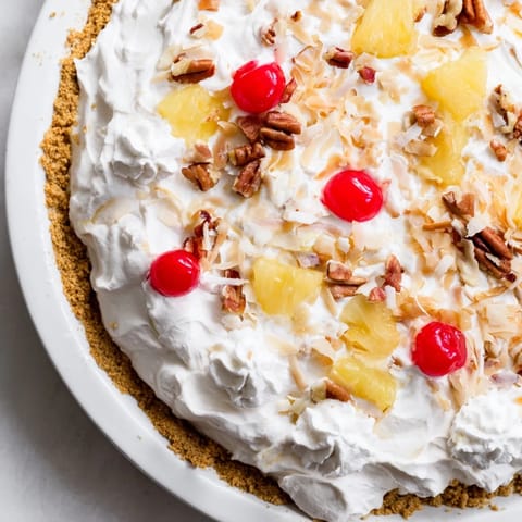 A slice of Millionaire Pie reveals creamy filling with cherries, coconut, and pecans in its crust.