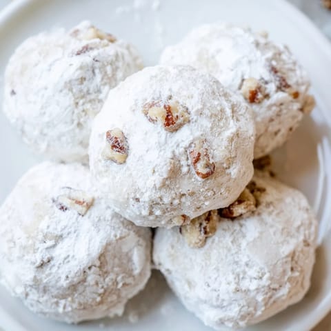 Close-up of fluffy Mexican Wedding Cookies, buttery shortbread with pecans, perfect for holidays.