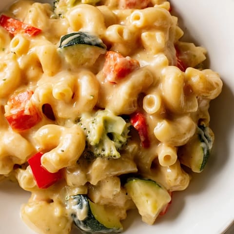 A comforting bowl of Roasted Veggie Mac & Cheese features tender pasta tossed with caramelized vegetables and a velvety three-cheese sauce.  