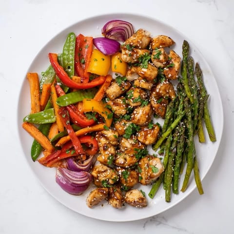 Sizzling Sheet Pan Honey Garlic Chicken & Veg with colorful peppers and asparagus roast on a single pan, drenched in a glossy, sweet-savory sauce.