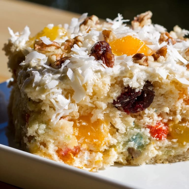 Warm, frosted fruit cocktail cake, with visible pieces of fruit ready to enjoy as dessert.