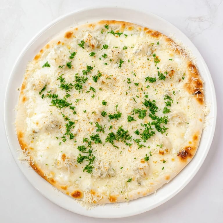 A rustic Creamy Garlic White Pizza slice with velvety garlic sauce and melted cheese, served on a wooden board.