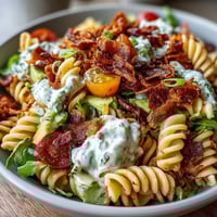 Creamy BLT pasta salad with crispy bacon, ripe avocado, and fresh tomatoes in a tangy dressing.