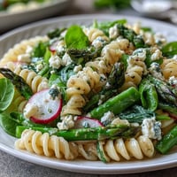 Spring Pasta Salad with Lemon Vinaigrette and Radishes - A colorful pasta salad bursting with crisp radishes, tender asparagus, and sugar snap peas, all tossed in a bright lemon dressing.